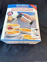 Front of sealed box showing torch and ramekins