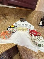 All items grouped: four teapots, two mugs, six tumblers, cut-glass votive cups