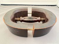 overall side view showing oval wooden frame, central screw handle, brass hardware