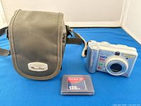 Front view of Canon PowerShot A60 camera, SanDisk 128 MB CompactFlash card, and Canon PowerShot carrying case