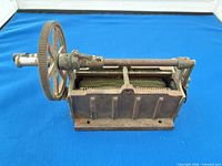 full view of cast iron hand-crank magneto with flywheel and internal components