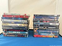 Two tall stacks of assorted DVD keepcases on a table