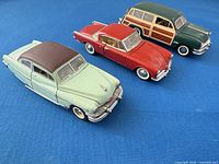 Three Franklin Mint diecast classic cars lined up showing overall colours and styling