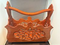 Front view of carved mahogany magazine rack assembled