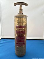 Full view of brass fire extinguisher showing handle and body