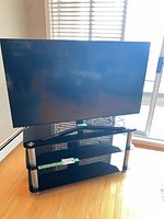 Front view of Samsung TV on glass corner stand