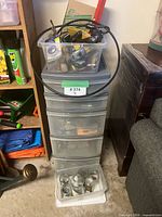 Full view of five-drawer plastic tower with top bin and bottom tub of jars
