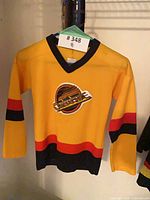 Front view of yellow kids Canucks jersey on hanger