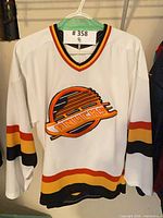 Front view of white Vancouver Canucks flying skate CCM jersey on hanger