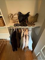 Overall view of handbags on shelf, shoes on rod and hanging jackets and sweaters