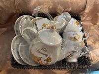 Basket containing complete 50th Anniversary porcelain tea set wrapped in plastic