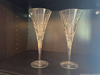Pair of Royal Doulton crystal champagne flutes standing side by side on shelf
