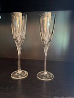 Two clear cut crystal champagne flutes on shelf