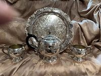 Front view of complete four-piece silverplate tea set on tray