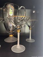 Pitcher and glasses close-up showing gold rim and frosted stem details