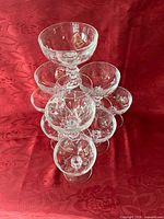Stack of eleven clear glass champagne coupes showing overall set