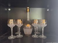 Decanter centered with six glasses around, full set view