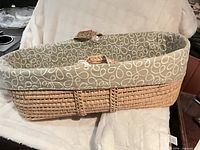 Side view of wicker Moses basket with liner and handles