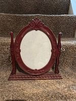 Front view of carved wood oval dresser mirror