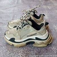 Pair of beige/black Balenciaga Triple S sneakers showing overall condition
