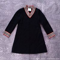 Full view of black Burberry kids dress laid flat showing overall style and stripe trim