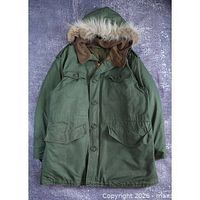 Front view of olive green Canadian Forces ECW parka with fur-trim hood and four pockets