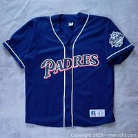 Full front view of navy Padres jersey showing piping, front script, jock tag, sleeve patch position