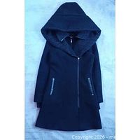 Full view of black hooded coat showing length, pockets, zipper, large hood