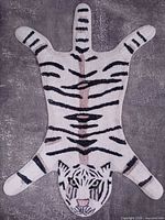 Full view of tiger-shaped tufted rug on grey floor