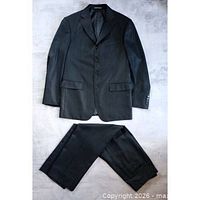 Full view of jacket and trousers laid flat