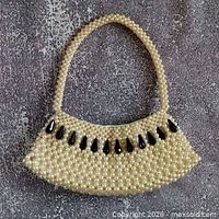 Front view of pearl-beaded handbag with black accent beads and handle