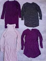 Four rib-knit long-sleeve mini dresses laid flat (purple, charcoal, blush pink, plum)