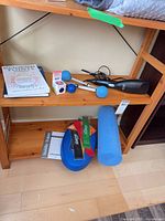 Shelf showing books, massager, dumbbells, acuballs, foam roller, flexbands, stability trainer