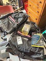 Two black rear panniers with product leaflet and boxed bike computer on workbench