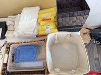 Overview showing linens, microfibre cloth pack, multiple baskets, plastic containers