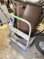 Overall view of dolly with handle upright, rain barrel sitting on deck