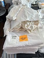 Stacked white microfibre sheets with plastic-bagged covers on top