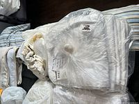 Stack of white percale sheets bundled in plastic wrap