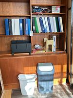 Overall view of shelf unit showing binders, organizers, file folders, gift bags and two wastebaskets