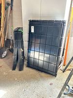 Folded crate with liner leaning against wall, stacked pen panels beside