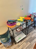 Overall view showing toys, bowls, treat trays, life jacket, tie-out cable, cooling mat and two metal food bins