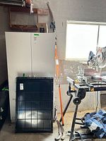 Full view of Fiskars pole saw with two hand saws nearby