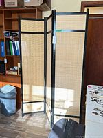 Full view of three-panel privacy screen standing partially folded