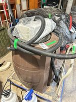 Overall view of rain barrel on dolly with hose and packaged diverter on lid