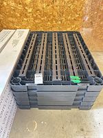 Stacked black plastic shelves and support posts