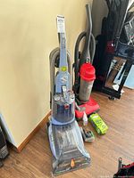 Hoover MaxExtract 77 cleaner, Dirt Devil vacuum, HEPA filter and cleaning solution visible