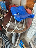 Wheelbarrow showing new wheel, ladder supports, rust, liner partly folded