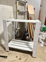 Front view of first white wooden shelf unit showing frame and two slatted shelves