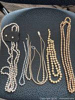 All necklaces and earrings laid out on chair showing colors and lengths
