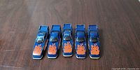 Five blue Hot Wheels cars top view showing paint wear